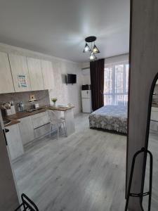 a room with a bed and a kitchen with a table at Studio apartment for rent in Almaty