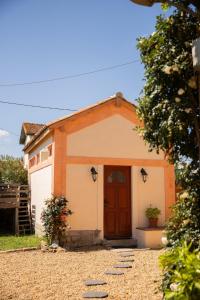 a small house with a brown door in a yard at La maisonnette de la gare in Lieuran-lès-Béziers