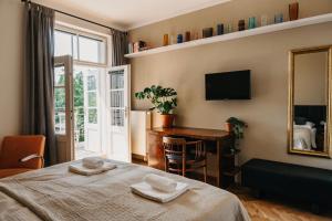 Un dormitorio con una cama, un escritorio y un espejo. en Bed&Breakfast & Apartment Klafé, en Brno