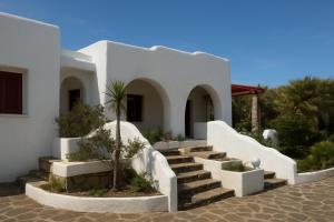 a white house with stairs and a palm tree at Villa Adele Monopoli,Puglia in Faccia di Trippa