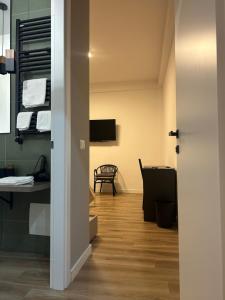 a hallway with a room with a table and a television at A Due Passi Dalla Scalinata Rooms in Caltagirone
