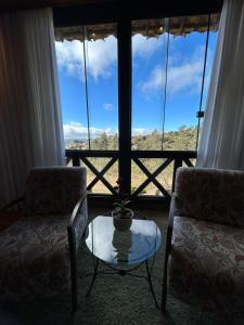 a room with two chairs and a table and a window at Pousada Carumbé Lavras Novas in Lavras Novas +1 photo