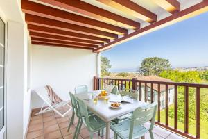 a patio with a table and chairs on a balcony at Résidence Pierre & Vacances La Villa Maldagora in Ciboure