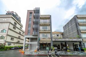 two tall buildings next to each other on a street at 花蓮發現民宿-無人民宿自助入住-包棟可烤肉可麻將 in Hualien City