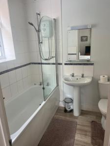 a bathroom with a sink and a shower and a toilet at Brantwood Guest House in Christchurch