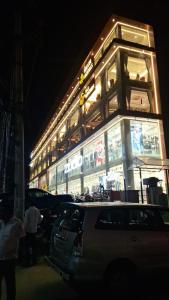 a building lit up at night with cars parked outside at Ricch Hotels in Hyderabad