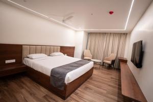 a hotel room with a bed and a television at Ricch Hotels in Hyderabad