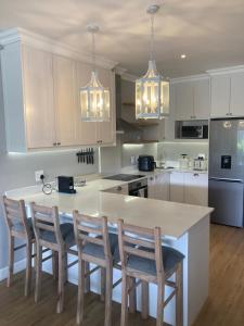 een keuken met witte kasten en een tafel met stoelen bij Villa 121 Franschhoek Lermitage in Franschhoek