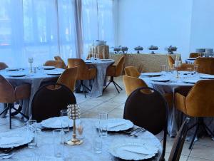 a dining room with tables and chairs with plates and glasses at Sapphire Hotel in Bloemfontein