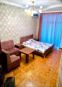 a bedroom with a bed and a chair and a table at Coastal Inn in Baku