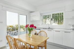 a kitchen with a table with a vase of flowers on it at Amazing Sea View -3 Bed Ground Floor Garden Apartment in Kérynia