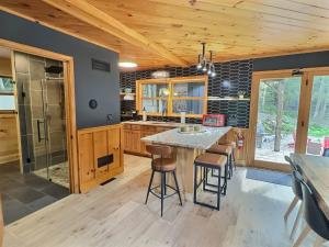 a kitchen with a table and stools in a room at Cabin in Ellicottville, Fire Place & Hot Tub in West Valley