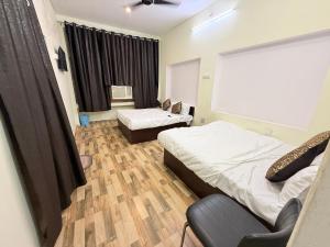 バラナシにあるKrishna valley innのベッドが2つと窓があるホテルの部屋