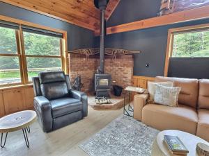 a living room with a couch and a stove at Cabin in Ellicottville, Fire Place & Hot Tub in West Valley