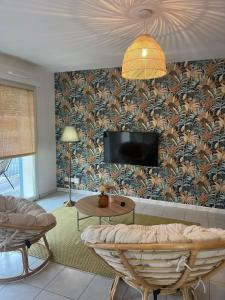 Una sala de estar con un sofá y un televisor en una pared. en Les Bains Bohème, en Amnéville 15 fotos más