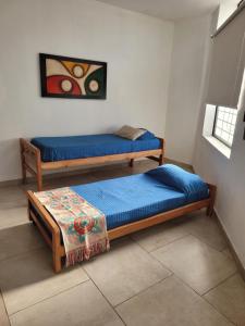 a room with two beds and a table in it at Carmel Apart Paraná in Paraná