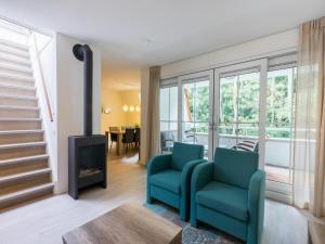 a living room with a fireplace and a blue chair at Holiday Home in Koudekerke near the Beach in Koudekerke +31 photos
