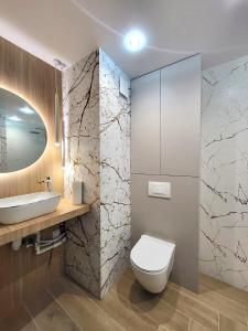 a bathroom with a white toilet and a sink at Apartament Kolberga in Radom