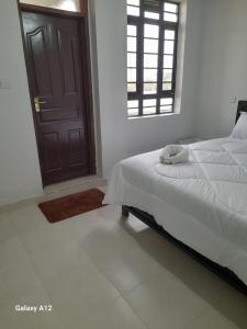 a bedroom with a bed and a window and a door at Mugo Queen's Stay in Lotus Island