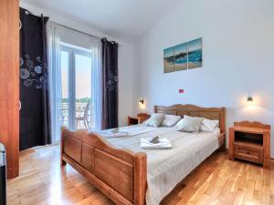 a bedroom with a large bed and a large window at Holiday Home VIlla Eldina by Interhome in Škatari