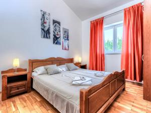 a bedroom with a large bed with red curtains at Holiday Home VIlla Eldina by Interhome in Škatari