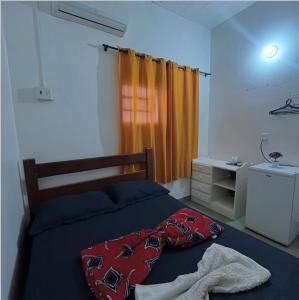 a bedroom with a bed with a blanket on it at HOTEL TAPAJOS Marabá in Marabá
