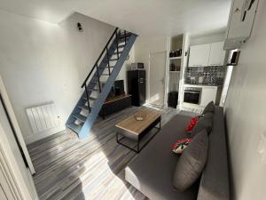 ein Wohnzimmer mit einer Couch und einer Treppe in der Unterkunft Le Fraisou Maison individuelle cosy proche Disney et Paris in Saint-Thibault-des-Vignes