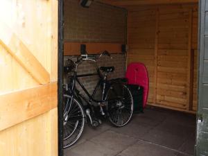 ein Fahrrad in einer Garage mit einem Snowboard geparkt in der Unterkunft Holiday Home Bungalowpark It Wiid by Interhome in Eernewoude