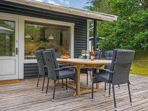 a patio with a wooden table and chairs on a deck at Holiday Home Sverkel - 700m from the sea by Interhome in Hornbæk