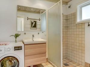 a bathroom with a washing machine and a sink at Holiday Home Sverkel - 700m from the sea by Interhome in Hornbæk
