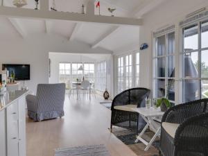a white living room with chairs and a table at Holiday Home Ylermi - 1-5km from the sea by Interhome in Dronningmølle
