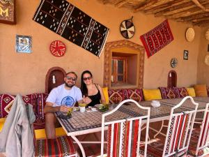 a man and a woman sitting at a table at Camp Desert Bivouac Chegaga in El Gouera
