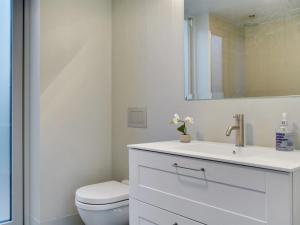a white bathroom with a toilet and a sink at Holiday Home Vanta - 10m from the sea by Interhome in Gilleleje +21 photos