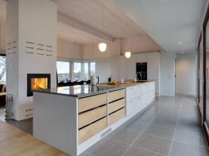 a kitchen with white cabinets and a fireplace at Holiday Home Vanta - 10m from the sea by Interhome in Gilleleje