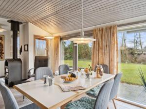 a dining room with a table and chairs and a large window at Holiday Home Guthbrand - 900m from the sea by Interhome in Gilleleje