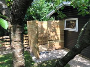 a wooden fence next to a house with a tree at Holiday Home Henryk - 500m from the sea by Interhome in Gilleleje