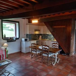 une cuisine et une salle à manger avec une table et des chaises dans l'établissement Maison de campagne, 