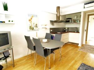 a kitchen and dining room with a table and chairs at Apartment Magnus - 6km from the sea by Interhome in Åkirkeby +7 photos