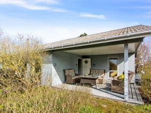 a patio with two chairs and a table on a house at Holiday Home Bondi - 150m from the sea by Interhome in Åkirkeby