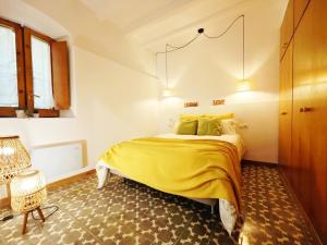 a bedroom with a yellow bed and a chair at Apartament Colònia Cal Rosal in Berga