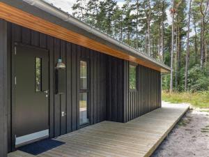 une maison avec une terrasse en bois dans les bois dans l'établissement Holiday Home Anarosa - 200m from the sea by Interhome, à Vester Sømarken 24 autres photos