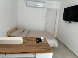 a room with a bed with two remote controls on a table at BEACH BAY suit in Shelomi