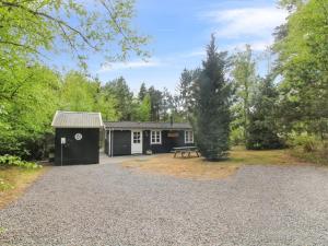 a shed with a picnic table in front of it at Holiday Home Zeytun - 800m from the sea by Interhome in Neksø