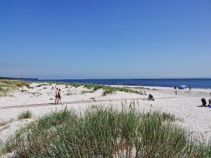 a group of people walking on a beach at Holiday Home Zeytun - 800m from the sea by Interhome in Neksø +15 photos