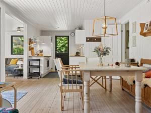 a kitchen and living room with a table and chairs at Holiday Home Lasse - 1-5km from the sea by Interhome in Græsted