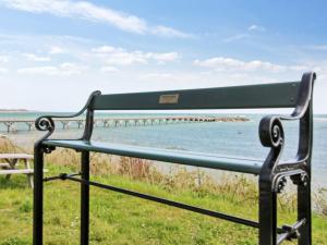 a bench sitting next to a body of water at Holiday Home Nikolce - 250m from the sea by Interhome in Rønne