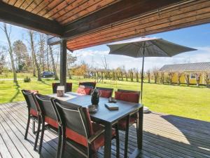 a table with chairs and an umbrella on a deck at Holiday Home Nikolce - 250m from the sea by Interhome in Rønne