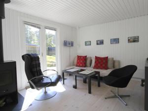 ein Wohnzimmer mit einer Couch und einem Tisch und Stühlen in der Unterkunft Holiday Home Talvikki - 250m from the sea by Interhome in Neksø