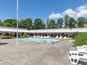 a swimming pool with lounge chairs and a building at Apartment Melita - 300m from the sea by Interhome in Neksø +17 photos