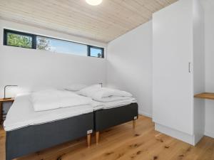 une chambre avec un lit dans une pièce blanche dans l'établissement Holiday Home Gonne - 350m from the sea by Interhome, à Vester Sømarken